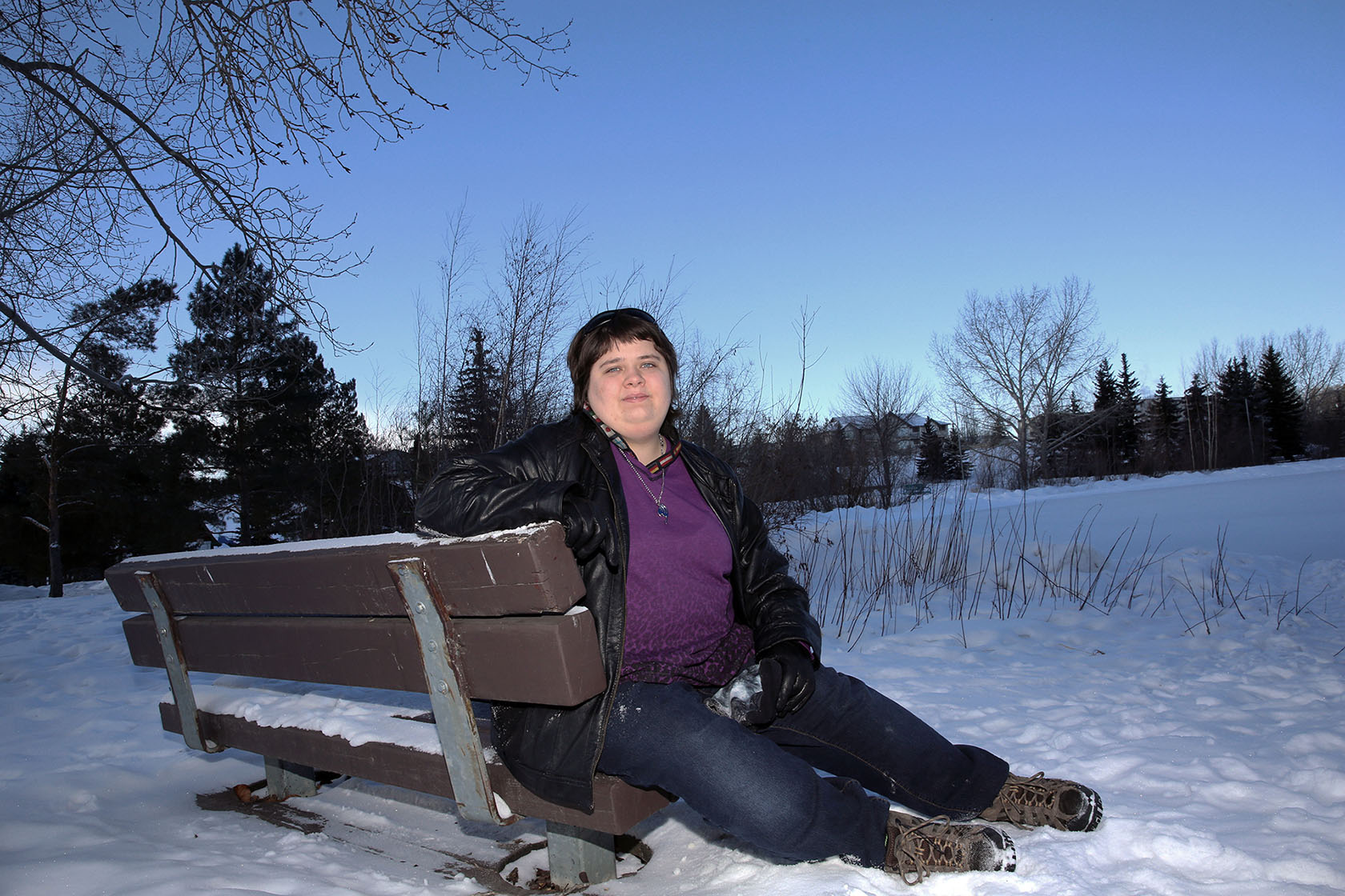 Photo de Jenna Aiken, dans un décor hivernal, souriant à l’appareil photo.